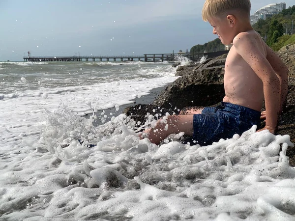 Un ragazzino in costume da bagno sta giocando sulla spiaggia . — Foto Stock