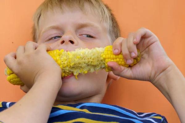 Niño comiendo mazorca de maíz hervida . —  Fotos de Stock