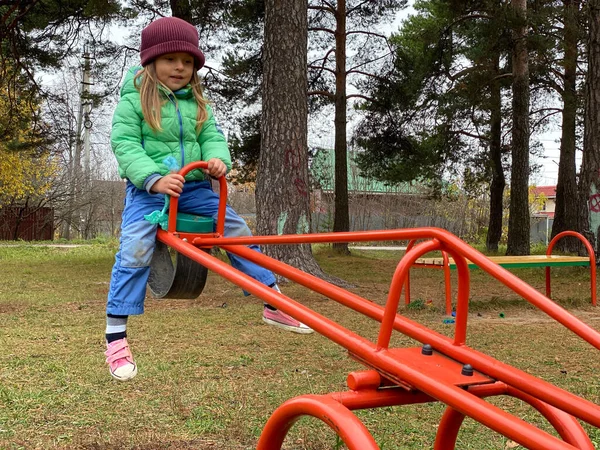 Little baby girl swinging on the playground. — Stock Photo, Image