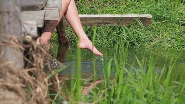 Mädchen ruht sich auf Seebrücke nahe kleinem Fluss aus. — Stockvideo