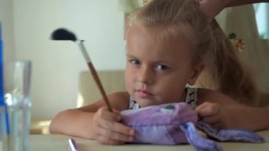 Anne üzgün kızını tarıyor.