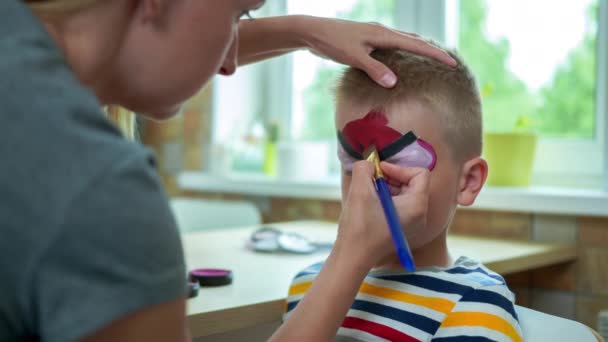 Kvinnan ritar på barnets ansikte — Stockvideo