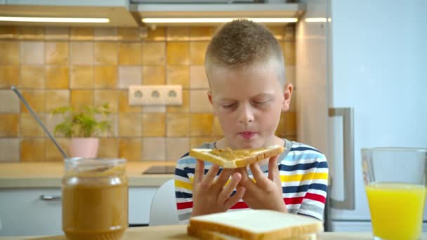 Kleine jongen die sandwich eet met pindakaas — Stockvideo