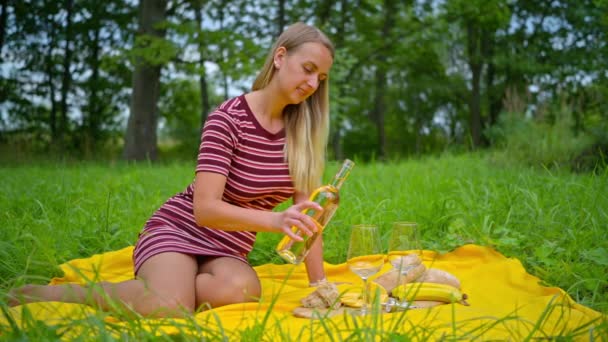 Mulher relaxante ao ar livre, derramando vinho no copo — Vídeo de Stock