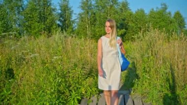 Sırt çantalı kadın turist kırsal bölgelerde yürüyüş yapıyor.