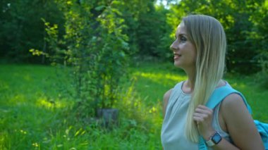 Sırt çantalı kadın turist kırsal bölgelerde yürüyüş yapıyor.