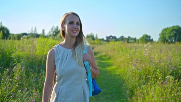 Kvinna turist med ryggsäck är vandring i landsbygdslandskap — Stockvideo