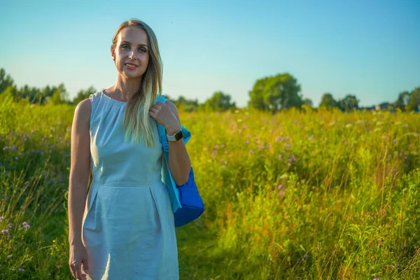 Женщина-туристка с рюкзаком путешествует по сельским пейзажам — стоковое фото