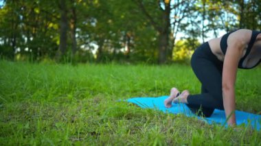 Parktaki kadın dizüstü bilgisayarla spor yapıyor.