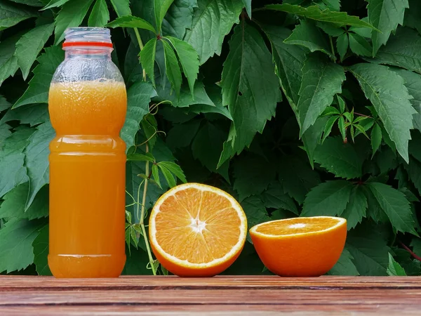 Świeży domowej roboty sok pomarańczowy w butelce w ogrodzie — Zdjęcie stockowe