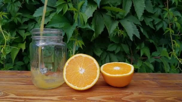 Im Garten frischen hausgemachten Orangensaft ins Glas gießen — Stockvideo