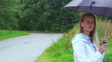 Yağmurlu günlerde kırsal alanda şemsiyesi olan bir kadın.