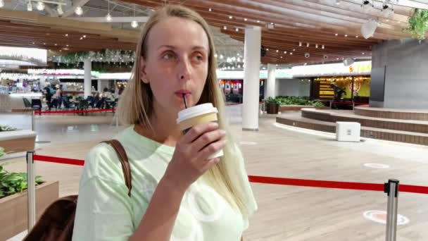 Vrouw die koffie drinkt in het winkelcentrum — Stockvideo