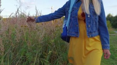 Mısır gevreği tarlasında yürüyen ve bitkilere dokunan bir kadın.