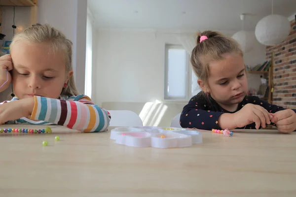Dos bebé niña está haciendo pulseras de cuentas — Foto de Stock