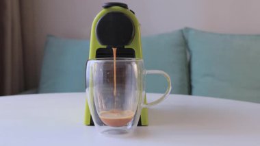 Modern bir kahve makinesinden şeffaf bir cam fincana taze espresso dökülüyor. Güne aromatik kafein takviyesiyle mükemmel bir başlangıç..
