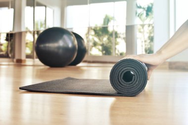 Kadın onu mat bir yoga sınıfına sonra ahşap zemin üzerinde haddeleme.