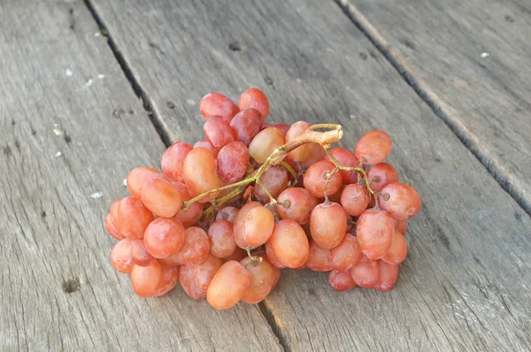 Bunch of red grapes on old wooden table Fundo — Fotografia de Stock