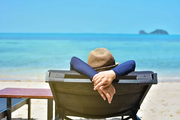 Женщина отдыхает на тропическом пляже в шляпе — стоковое фото