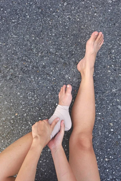 赛跑者以踝关节损伤持有脚来减轻疼痛. — 图库照片