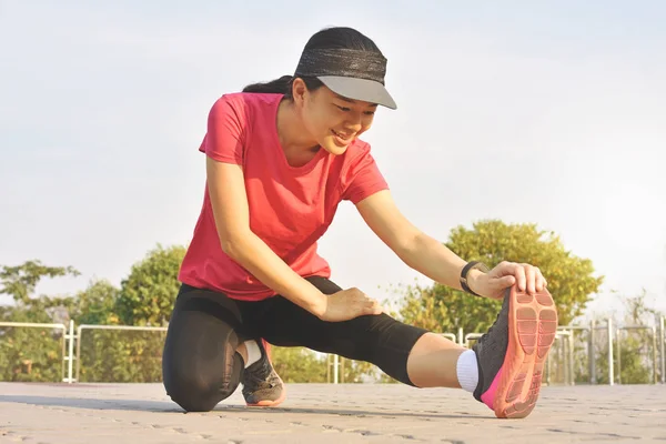 年轻健身妇女赛跑者舒展腿在奔跑在公园之前 — 图库照片