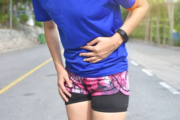 Female runner suffering have stomach pain during workout