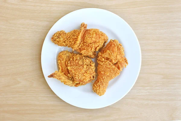 Ayam goreng renyah di piring putih di atas meja kayu — Stok Foto