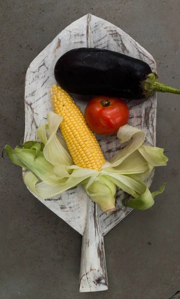 tomato, eggplant and corn over a wooden leave