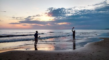 gün batımı: iki kardeş plajda kürek oynuyor