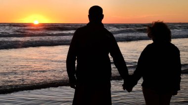 bir günbatımı arka plan ile gölge yaşlı çift