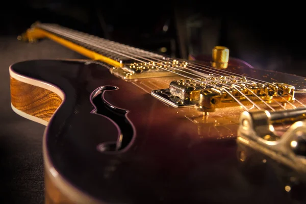 Sunburst elektro gitar ile pirinç mekaniği ve parlak renkler koyu gölgeli arka plan üzerinde closeup