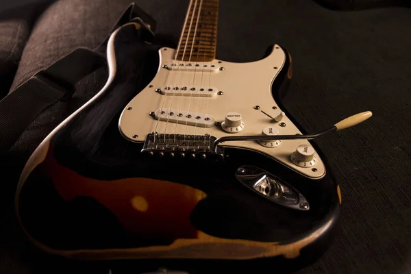 Kuvvetli güneş ışığı renginde elektro gitar Close-up yıpranmış efekti oluşturmak için belirli noktalarda kaldırıldı siyah boya ile kaplı