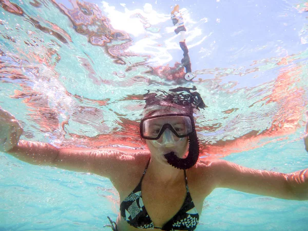 Mujer joven disparando en el agua desde abajo con los brazos abiertos con mas — Foto de Stock