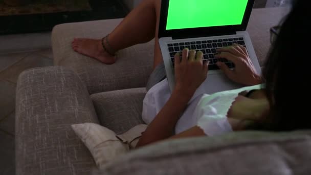 一位年轻女子在笔记本电脑上工作 家里的绿屏坐在客厅的屏幕上 — 图库视频影像