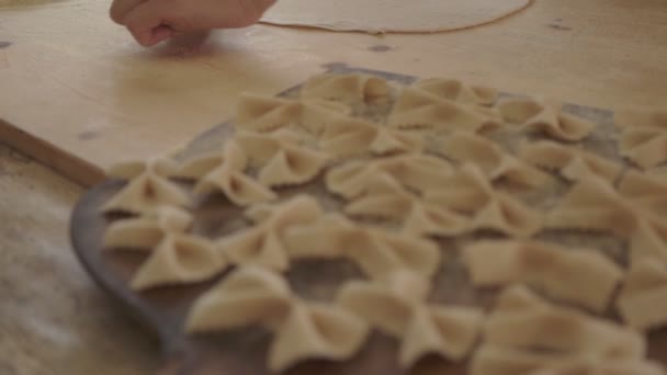 デュラム小麦粉と自家製ビーガンフォールパスタのプロセスを閉じます 料理人は生地を伸ばすためにローリングピンを使用しています 伝統的なイタリアのパスタ 女性は台所で料理を調理します — ストック動画