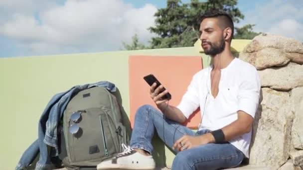 Garvade Unga Kaukasiska Mannen Lyssnar Musik Sin Smartphone Sitter Bänk — Stockvideo
