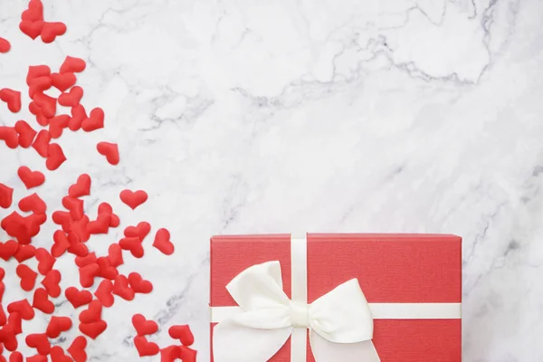 düz-Valentine arka plan kırmızı hediye kutusu ve küçük kalpler şekli masaya lay. 