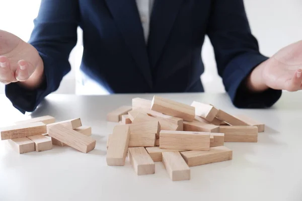 Closeup of business women playing wood blocks stack game, concept of business growth, gambling, risk, bankrupt.