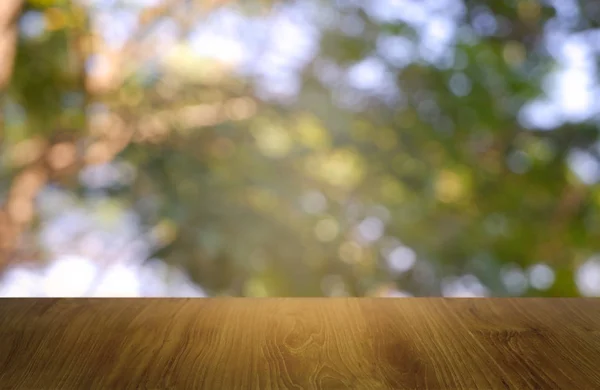 Пустой деревянный стол перед абстрактным размытым зеленым садом — стоковое фото