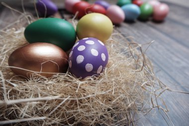 Ahşap masa üzerinde yuvarenkli Paskalya yumurtaları kapatın.