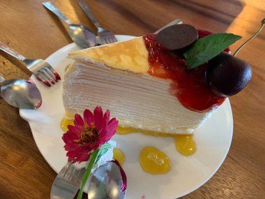 Kırmızı reçelli, kirazlı ve çiçekli yakın plan krep..