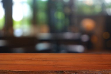 Soyut bulanık kafenin önündeki boş ahşap masa, geceleri restoran. Montaj ürünü görüntüleme veya tasarım için anahtar görsel düzeni - Resim
