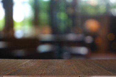 Soyut bulanık kafenin önündeki boş ahşap masa, geceleri restoran. Montaj ürünü görüntüleme veya tasarım için anahtar görsel düzeni - Resim