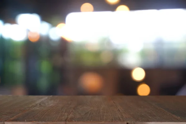 Soyut bulanık kafenin önündeki boş ahşap masa, geceleri restoran. Montaj ürünü görüntüleme veya tasarım için anahtar görsel düzeni - Resim