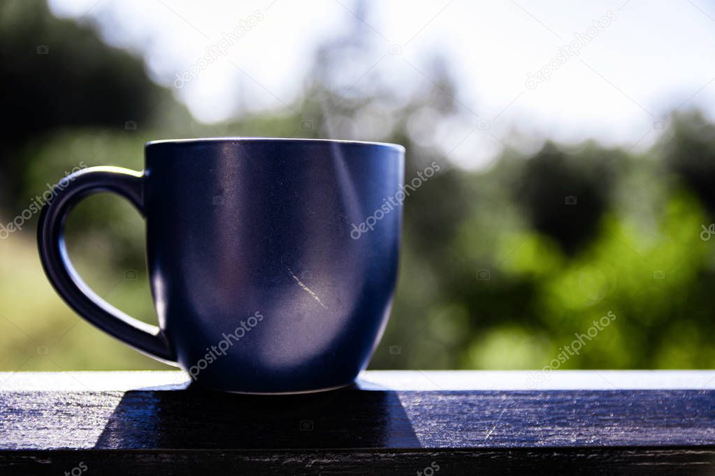 Blue Mug Of Morning Coffee On Balcony Ledge Against Sky