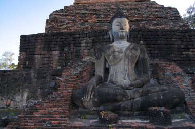 Buda heykeli önünde eski tuğla Chedi'nın Sukhothai Historical Park, Tayland oturan güzel