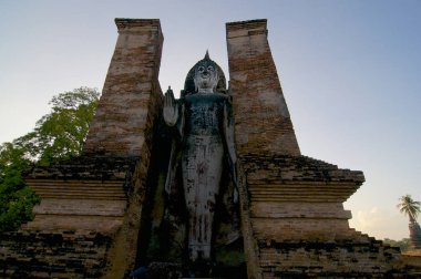 Düşük açılı resmini ayakta beyaz bir Buda heykeli'nın Sukhothai Historical Park, Tayland