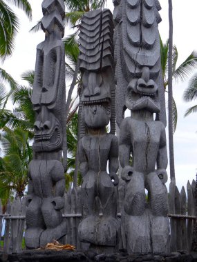 Close up picture of three beautiful wooden Tiki sculptures in the Pu'uhonua o Honaunau National Park, Big Island, Hawaii clipart