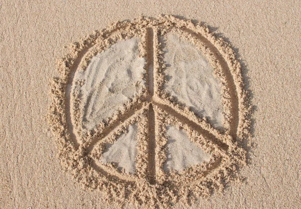 Peace symbol drawn and filled with white sand at Melasti beach in Bali, Indonesia