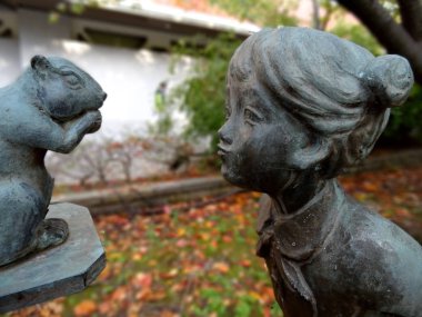 Bir sincap hayran bir kız endam bir bronz heykel resmi yakın